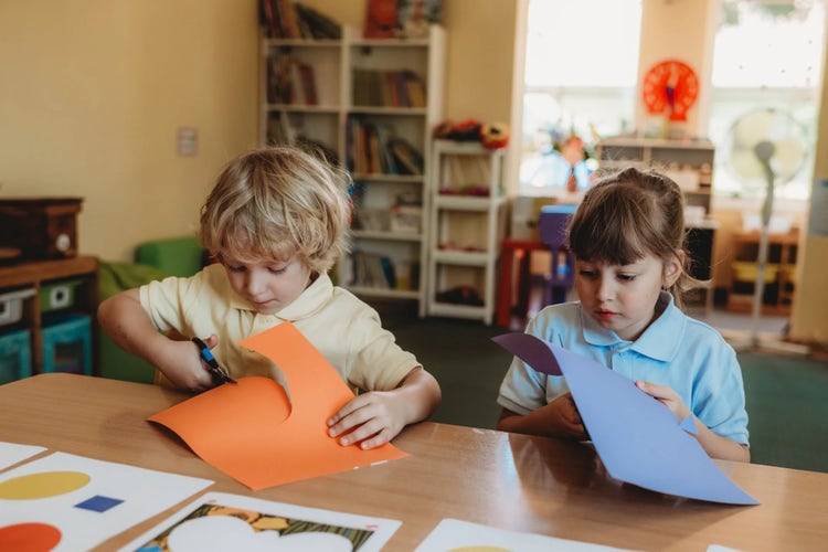 Dzieci z Przedszkola SCHERZO w Krakowie uczestniczą w kreatywnych zajęciach manualnych, samodzielnie wycinając kształty z kolorowego papieru. Tego typu aktywności rozwijają motorykę małą, koordynację wzrokowo-ruchową, koncentrację i precyzję, a jednocześnie zachęcają dzieci do samodzielnego działania i twórczego eksperymentowania.